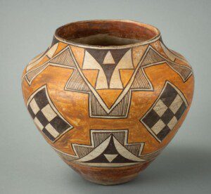 a piece of Pueblo pottery against a grey background