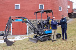 Excavator with two people shaking hands in foreground